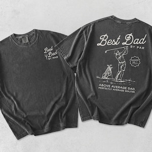Puede incluir: Dos camisetas gris carb&oacute;n. Una camiseta tiene "Best Dad by Par" impreso en la parte delantera. La otra camiseta tiene un gr&aacute;fico con tem&aacute;tica de golf en la parte trasera con el texto "Best Dad by Par", "Above Average Dad. Perfectly Average Golfer."