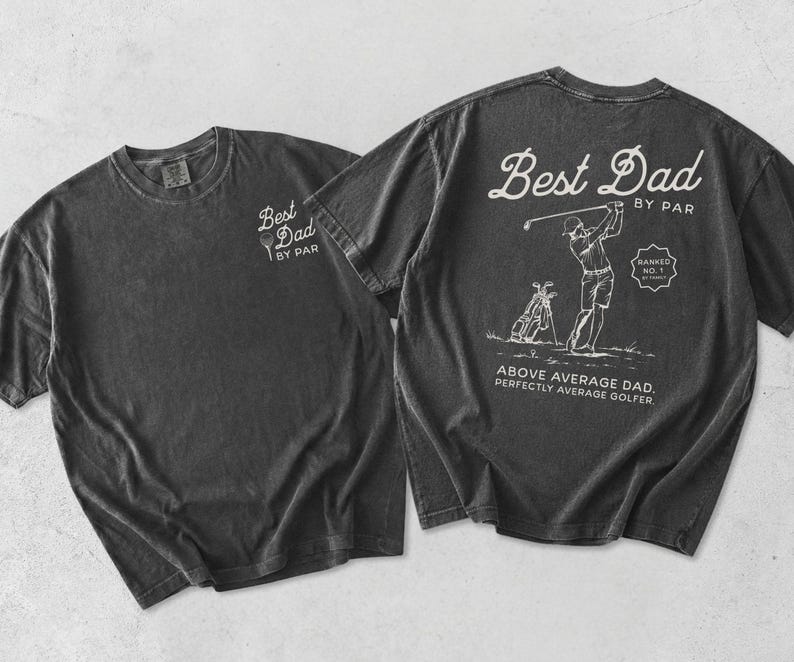 Puede incluir: Dos camisetas gris carb&oacute;n. Una camiseta tiene "Best Dad by Par" impreso en la parte delantera. La otra camiseta tiene un gr&aacute;fico con tem&aacute;tica de golf en la parte trasera con el texto "Best Dad by Par", "Above Average Dad. Perfectly Average Golfer."