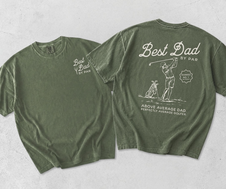 Puede incluir: Dos camisetas verde oliva. Una camiseta tiene impreso "Best Dad BY PAR" en la parte delantera. La otra camiseta tiene un gr&aacute;fico con tem&aacute;tica de golf en la parte posterior con el texto "Best Dad BY PAR", un golfista y las palabras "Above Average Dad. Perfectly Average Golfer."