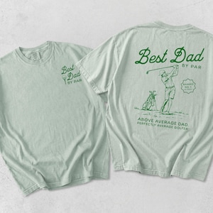 Puede incluir: Dos camisetas verde claro. Una camiseta tiene "Best Dad by Par" impreso en la parte delantera. La otra camiseta tiene "Best Dad by Par" en la parte trasera, con un gr&aacute;fico de golf y el texto "Above Average Dad. Perfectly Average Golfer."