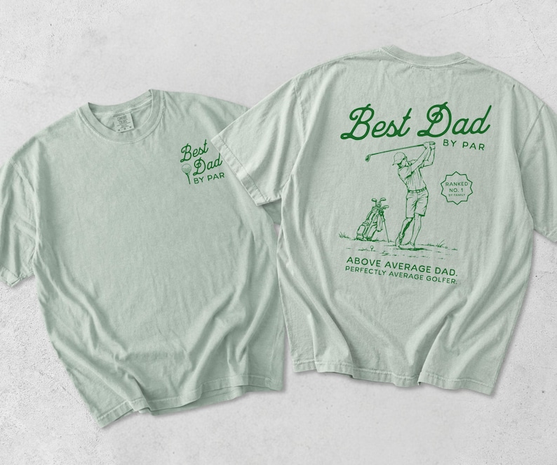 Puede incluir: Dos camisetas verde claro. Una camiseta tiene "Best Dad by Par" impreso en la parte delantera. La otra camiseta tiene "Best Dad by Par" en la parte trasera, con un gr&aacute;fico de golf y el texto "Above Average Dad. Perfectly Average Golfer."