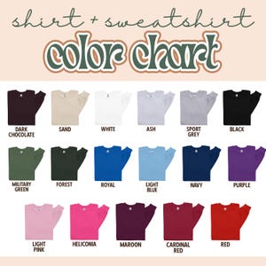 Op de afbeelding: Een kleurenkaart voor shirts en sweatshirts, met een verscheidenheid aan kleuren. De kaart bevat tinten als donkere chocolade, zand, wit, as, sportgrijs, zwart, legergroen, bos, koninklijk, lichtblauw, marine, paars, lichtroze, heliconia, kastanjebruin, kardinaalrood en rood.