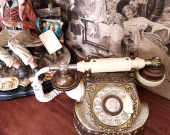 Telefono a disco vintage con decorazioni dorate.
