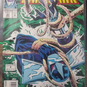 May include: A comic book cover featuring a blue and silver superhero character, Darkhawk, with a yellow and orange creature wrapped around his arm. The cover is green and has the text "MARVEL Comics" and "Darkhawk" in large, bold letters.