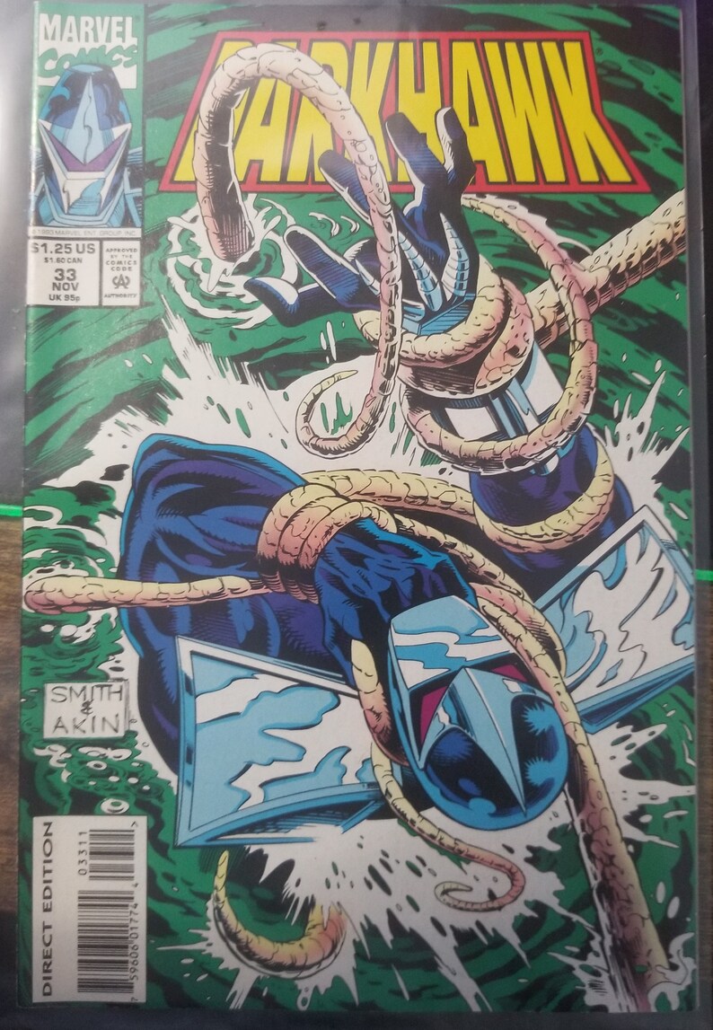 May include: A comic book cover featuring a blue and silver superhero character, Darkhawk, with a yellow and orange creature wrapped around his arm. The cover is green and has the text "MARVEL Comics" and "Darkhawk" in large, bold letters.