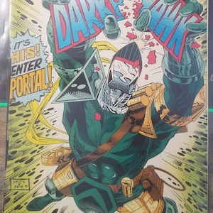 May include: A comic book cover featuring a green and black superhero character with a metallic helmet and a red and blue speech bubble that says "Darkhawk". The character is flying through the air with a yellow and green energy trail behind them. The text "It's His! Enter Portal!" is in a yellow speech bubble.
