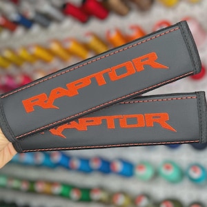 Funda para cinturón de seguridad de coche de cuero vegano bordado con código Raptor naranja • Almohadilla para el hombro personalizada