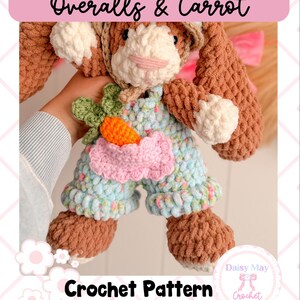 May include: A crochet bunny doll wearing blue overalls with a pink bow and a carrot. The bunny is brown and white, with a pink nose and a green carrot top. The text "Overalls & Carrot" and "Crochet Pattern" are visible.