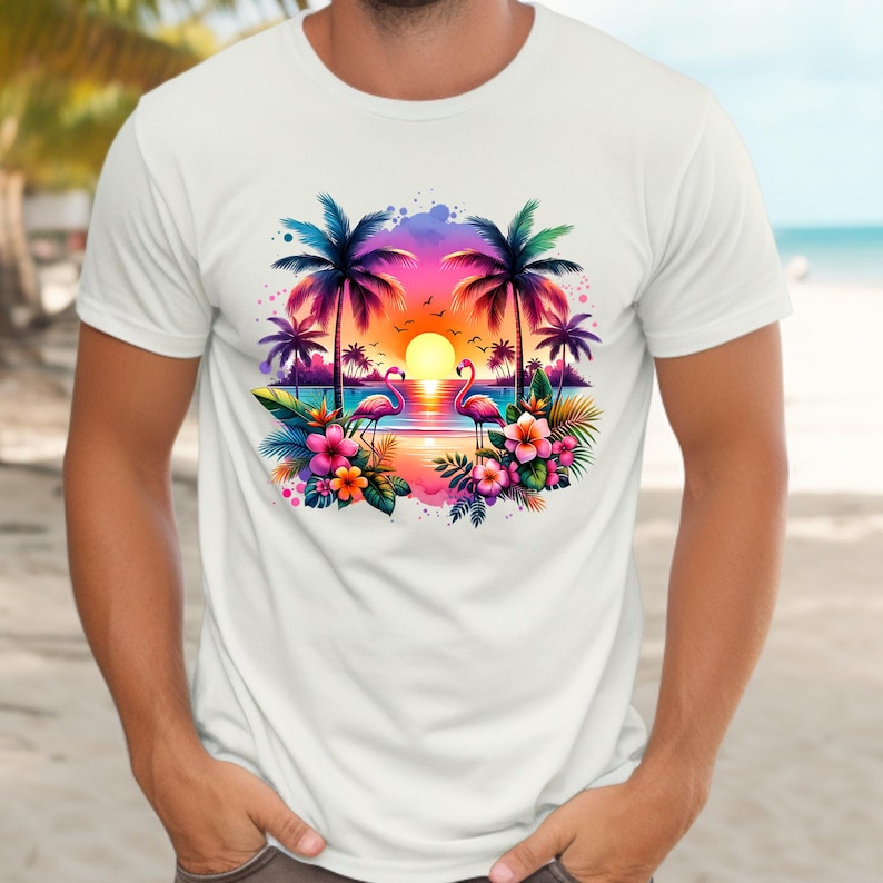 May include: White t-shirt with a colorful graphic print of palm trees, flamingos, and a sunset over the ocean. The graphic is surrounded by tropical flowers.