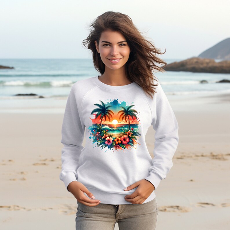 Pu&ograve; includere: Felpa bianca con una scena di tramonto tropicale colorata stampata sul davanti. La scena presenta due palme, un tramonto, onde oceaniche e fiori tropicali.