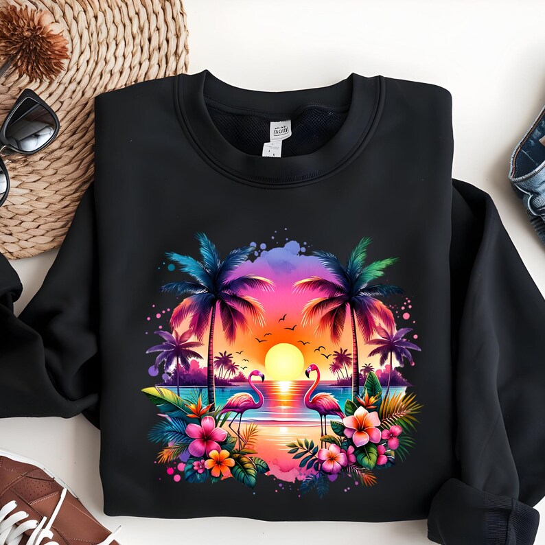 May include: Black sweatshirt with a colorful sunset scene featuring two pink flamingos, palm trees, and tropical flowers.
