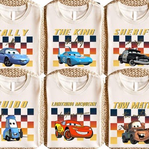 six white t-shirts with various cartoon car designs and text printed on them.