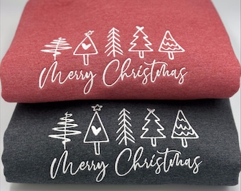 May include: Two folded sweatshirts, one red and one charcoal gray, stacked on top of each other. Each sweatshirt has a white graphic of Christmas trees and the words "Merry Christmas".