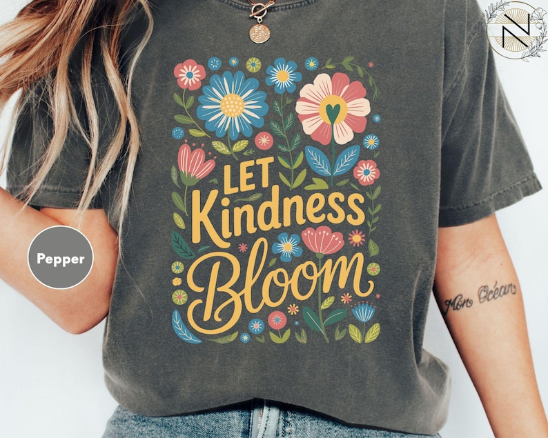 a woman wearing a t - shirt that says let kindness bloom