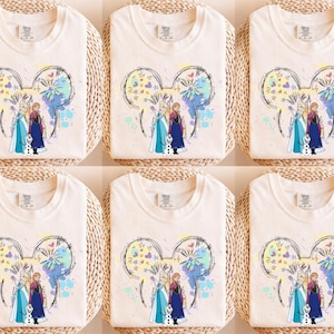 A collage of six white t-shirts featuring illustrations of characters from the Disney movie Frozen.