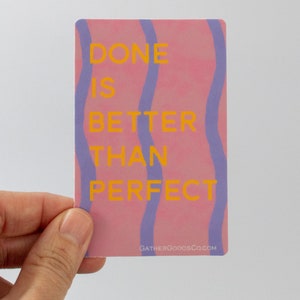 May include: Pink and purple sticker with the text "DONE IS BETTER THAN PERFECT" in yellow. The sticker has a website address at the bottom: GATHERGOODSCO.COM.