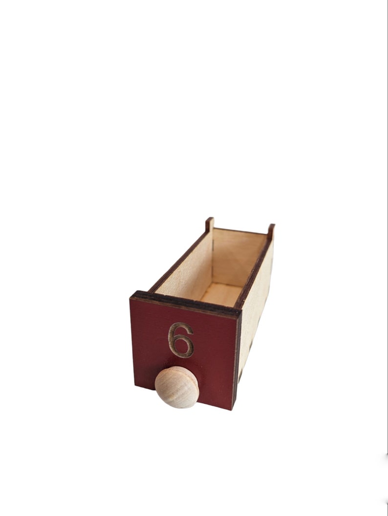 May include: A wooden box with a red front panel and a number "6" printed on it. The box has a small wooden knob on the front.
