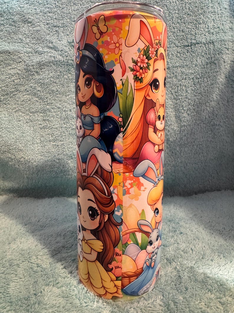 May include: A white ceramic mug with a black handle and the text "But First, Coffee" in a bold, black font. The mug is set against a blurred background, suggesting a cosy setting.