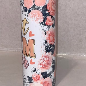 Puede incluir: Un vaso de acero inoxidable blanco con un dise&ntilde;o floral con rosas rosas y un fondo blanco y negro. El vaso tiene el texto "Hot Mom" con un coraz&oacute;n a cada lado del texto.