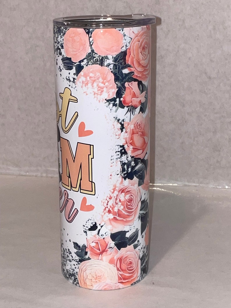 Puede incluir: Un vaso de acero inoxidable blanco con un dise&ntilde;o floral con rosas rosas y un fondo blanco y negro. El vaso tiene el texto "Hot Mom" con un coraz&oacute;n a cada lado del texto.