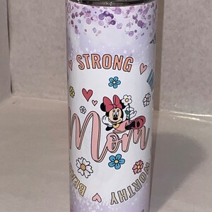 May include: A white stainless steel tumbler with a purple glitter background. It features a pink and white cartoon mouse with a red bow, holding a flower. The text "Strong Mom Worthy Beautiful" is printed around the mouse.