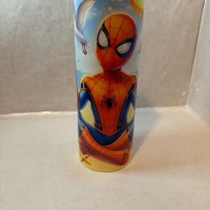 May include: A stainless steel tumbler with a colorful image of Spider-Man on a beach with seagulls flying overhead. The tumbler has a yellow, blue, and red design.
