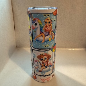May include: A white stainless steel tumbler with a colourful design featuring a girl with long blonde hair wearing sunglasses and a pink shirt riding a unicorn float in a pool. The tumbler also features a girl with red hair wearing a straw hat and sunglasses riding a unicorn float in a pool. The tumbler has a white background with blue and white waves and other summer-themed designs.