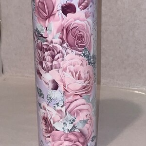 May include: A stainless steel tumbler with a floral design featuring pink roses and leaves on a white background.