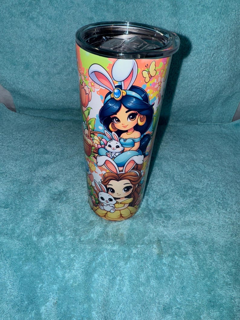 May include: A white ceramic mug with a black handle and the text "But First, Coffee" in a bold, black font. The mug is set against a neutral background, highlighting its simple design.