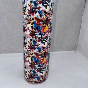 May include: A cylindrical stainless steel tumbler featuring a repeating pattern of Mickey Mouse dressed as various superheroes, including Captain America, Thor, and Spider-Man, set against a vibrant, multi-colored paint splatter background.