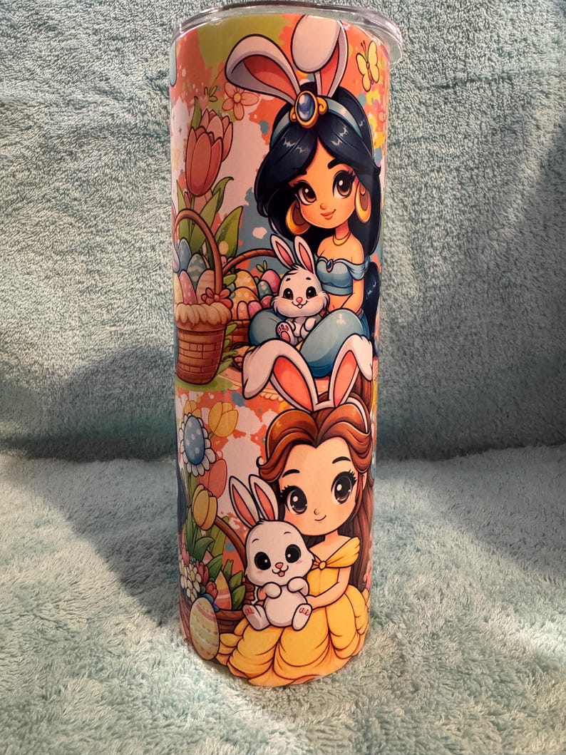 May include: A white ceramic mug with a black handle and the text "But First, Coffee" in a bold, black font. The mug is set against a blurred background, suggesting a cosy setting.