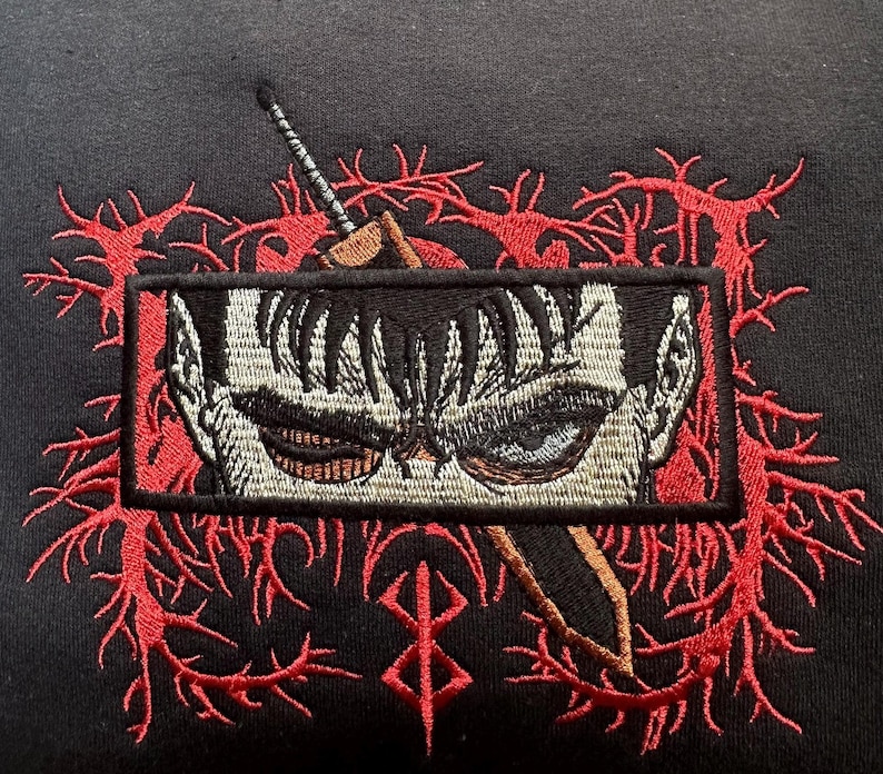 May include: Black embroidered patch with a red and white design. The patch features a close-up of a character's face with a sword behind it. The character has black hair and a serious expression. The sword is partially obscured by the character's face. The patch is surrounded by a red and white design that resembles thorns.