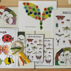 May include: A set of educational materials for children featuring colorful illustrations of insects, including a ladybug, butterfly, bee, caterpillar, and dragonfly. The set includes flashcards, activity sheets, and a magnifying glass. The text on the cards includes the letters "Bb", "Mm", "Cc", "Dd", and "Gg".