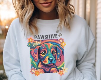 Könnte beinhalten: Weißer Pullover mit einem bunten Grafikdruck eines Hundefaces und dem Text "Pawsitive Vibes".