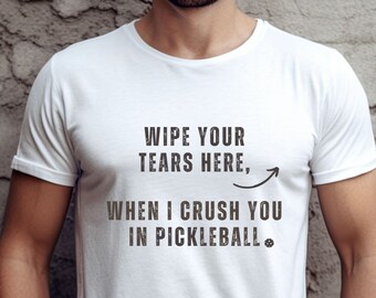 May include: White t-shirt with the text "Wipe your tears here, when I crush you in pickleball." with an arrow pointing to the left.