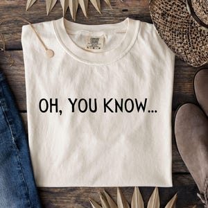 May include: A white t-shirt with the text "OH, YOU KNOW..." printed in black.