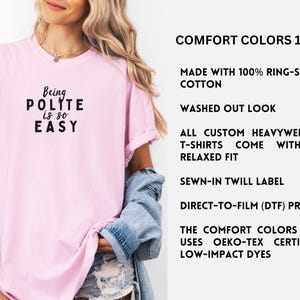 May include: Pink t-shirt with the text "Being POLITE is so EASY" in black. The shirt is made with 100% ring-spun cotton and has a relaxed fit. It is a heavyweight t-shirt with a sewn-in twill label and a direct-to-film print. The Comfort Colors 1717 uses Oeko-Tex certified low-impact dyes.