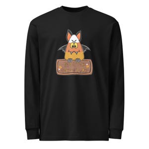 Puede incluir: Una camiseta negra de manga larga con un gráfico de un personaje de caramelo de maíz con alas de murciélago y colmillos. El personaje sostiene un letrero de madera que dice Fear The Candy Corn, con dos pequeñas ilustraciones de caramelo.