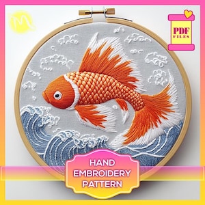 May include: Hand embroidery pattern featuring a detailed design of a goldfish swimming in waves. The pattern is in a wooden embroidery hoop.