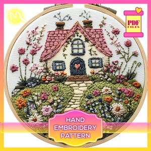 Peut inclure: Un motif de broderie à la main représentant un chalet blanc avec un toit rose et un chemin de pierre menant à la porte d'entrée. Le chalet est entouré d'un jardin avec des fleurs colorées et de la verdure. Le motif est encadré dans un cercle en bois.