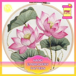 May include: A hand embroidery pattern featuring two pink lotus flowers with green leaves on a white background. The pattern is in a wooden embroidery hoop. The text "HAND EMBROIDERY PATTERN" is on a white rectangle with a pink border.