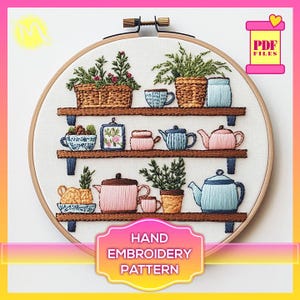 May include: Hand embroidery pattern featuring a set of shelves with various teacups, teapots, and plants. The shelves are brown wood with white trim. The teacups and teapots are in shades of blue, pink, and green. The plants are green and brown. The pattern is in a circular hoop.