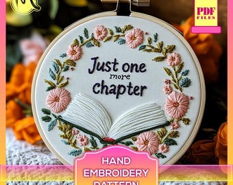Puede incluir: Un aro de bordado blanco con un diseño de corona de flores y el texto "Just one more chapter" y un libro abierto en el centro. El aro está sobre una tela de punto blanca y naranja. Patrón de bordado a mano.