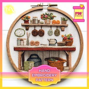 Op de afbeelding: Een handborduurpatroon met een keukenscène met een houten tafel, planken, potten, pannen en een mand met fruit. Het patroon is in een ronde hoepel en klaar om te borduren.