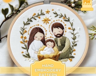 May include: A hand embroidery pattern featuring a nativity scene with Mary, Joseph, and baby Jesus. The design is surrounded by a wreath of green leaves and yellow flowers. The text "HAND EMBROIDERY PATTERN" is displayed below the image.