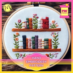 May include: A hand embroidery pattern featuring two shelves filled with colorful books and flowers. The pattern is in a hoop and the text "HAND EMBROIDERY PATTERN" is below the hoop.