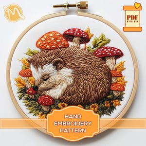 May include: Hand embroidery pattern featuring a sleeping hedgehog surrounded by mushrooms and flowers. The pattern is in a wooden embroidery hoop and includes the text "HAND EMBROIDERY PATTERN".