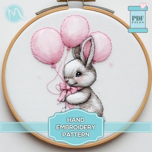 以下が含まれることがあります： ピンクの風船を持ったかわいいウサギが描かれた手刺繍のパターンです。パターンはフープに入っていて、「HAND EMBROIDERY PATTERN」というテキストが含まれています。