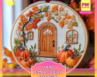 May include: Hand embroidery pattern featuring a small house with a door and windows, surrounded by autumn leaves and pumpkins. The pattern is stitched on a white fabric and framed in a wooden hoop.