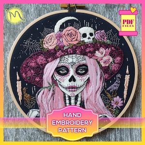 Könnte beinhalten: Ein Stickmuster für Handarbeiten mit einer von Día de Muertos inspirierten Frau mit rosa Haaren, einem violetten Hut, der mit Blumen geschmückt ist, und einem Totenkopfgesicht. Das Muster ist in einem Holzreifen gerahmt und enthält den Text "HAND EMBROIDERY PATTERN".